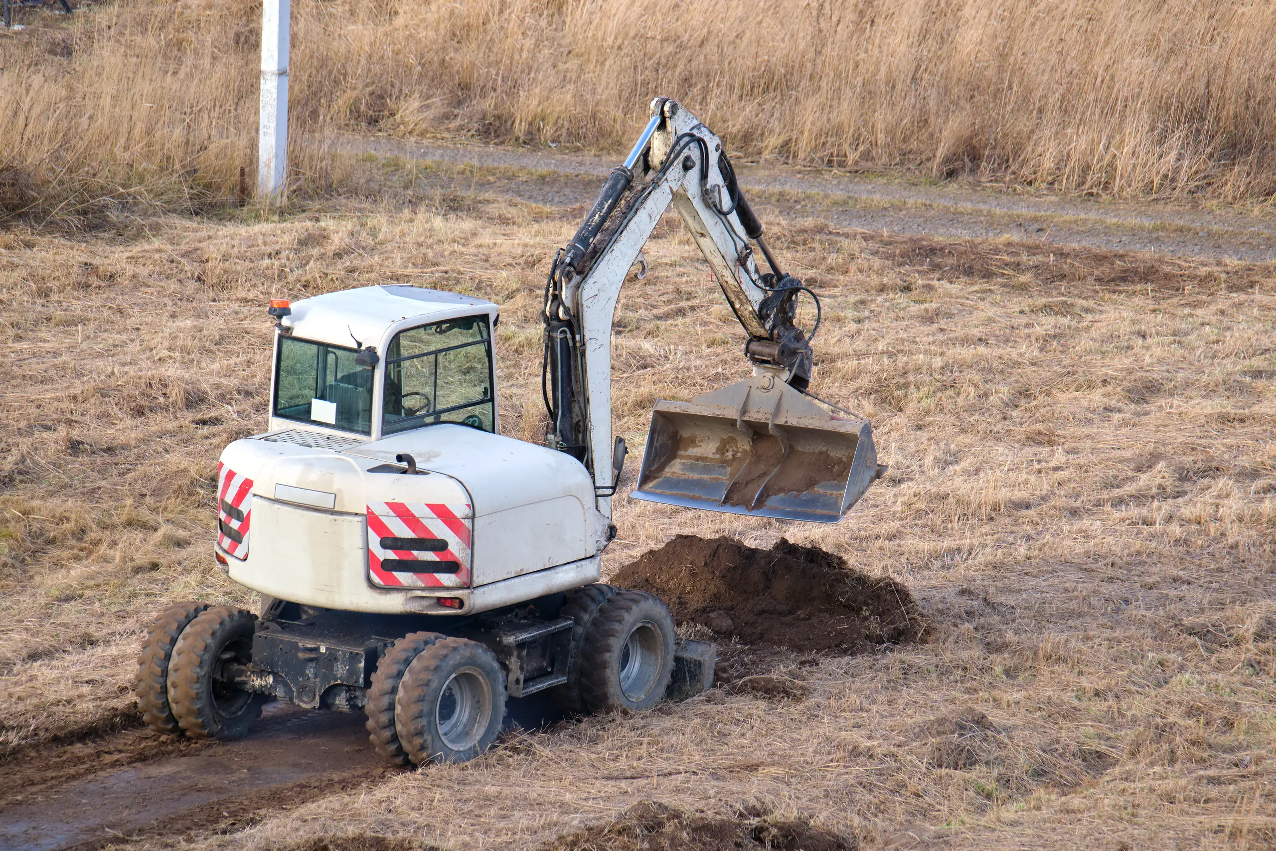 Minikoparka wykonująca prace ziemne na terenie inwestycji