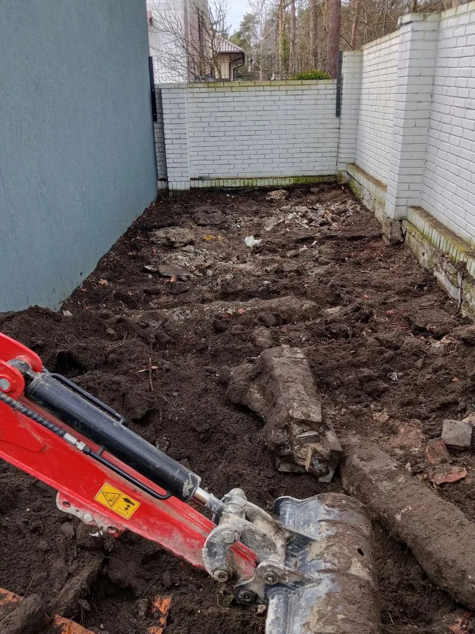 Widok terenu przygotowanego do inwestycji, z wykopem wykonanym minikoparką