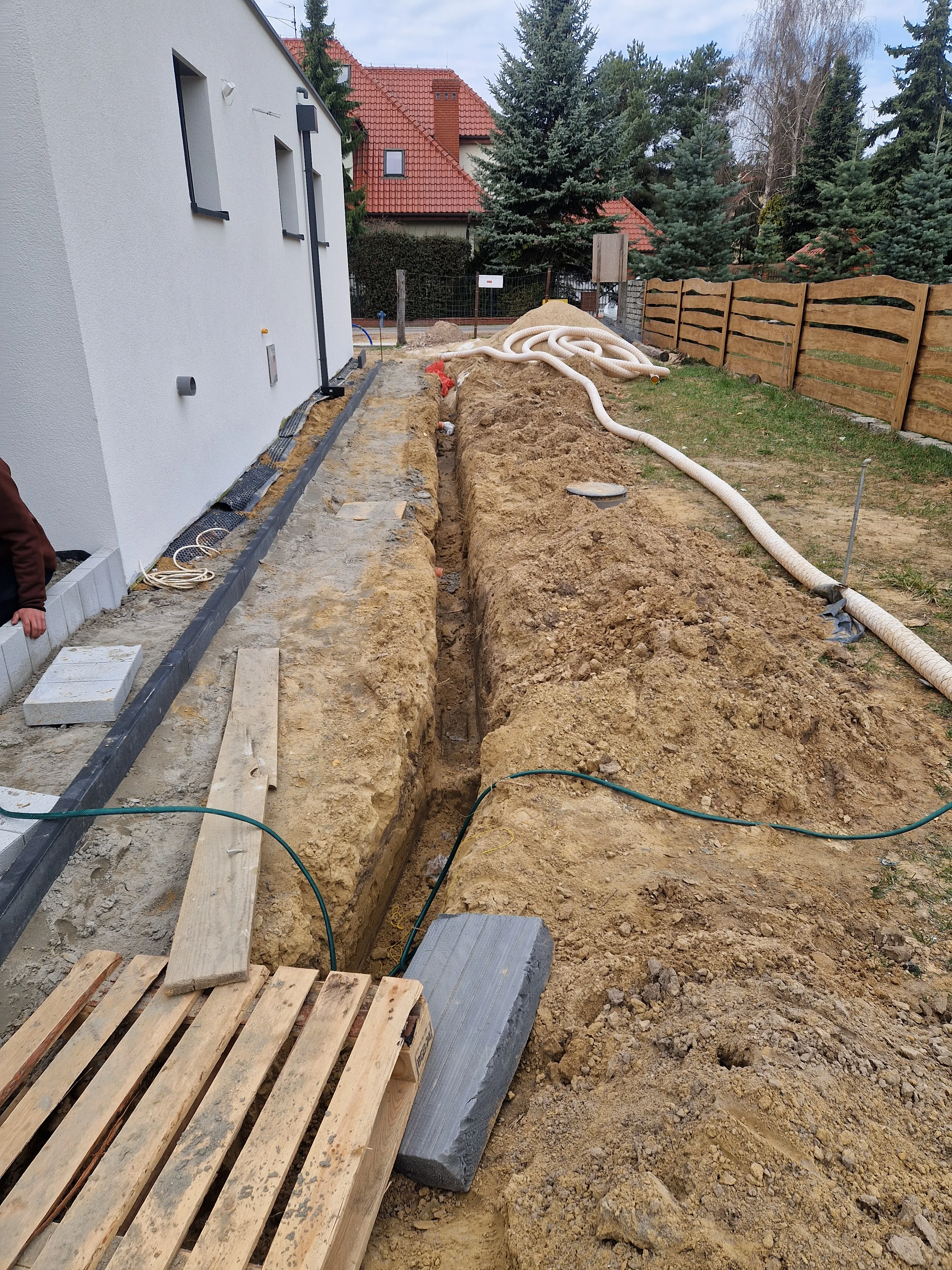 Wykop na terenie budowy, przygotowanie do instalacji drenażu i układania kostki brukowej